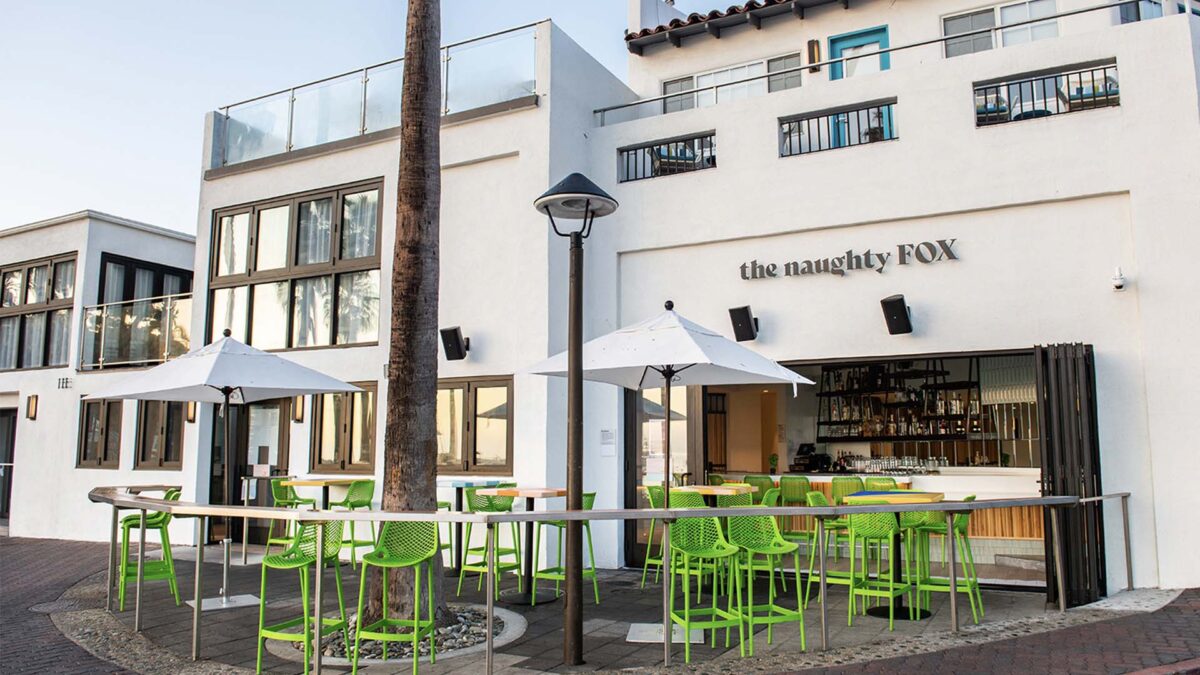 Exterior of The Naughty Fox with lime green tables and chairs