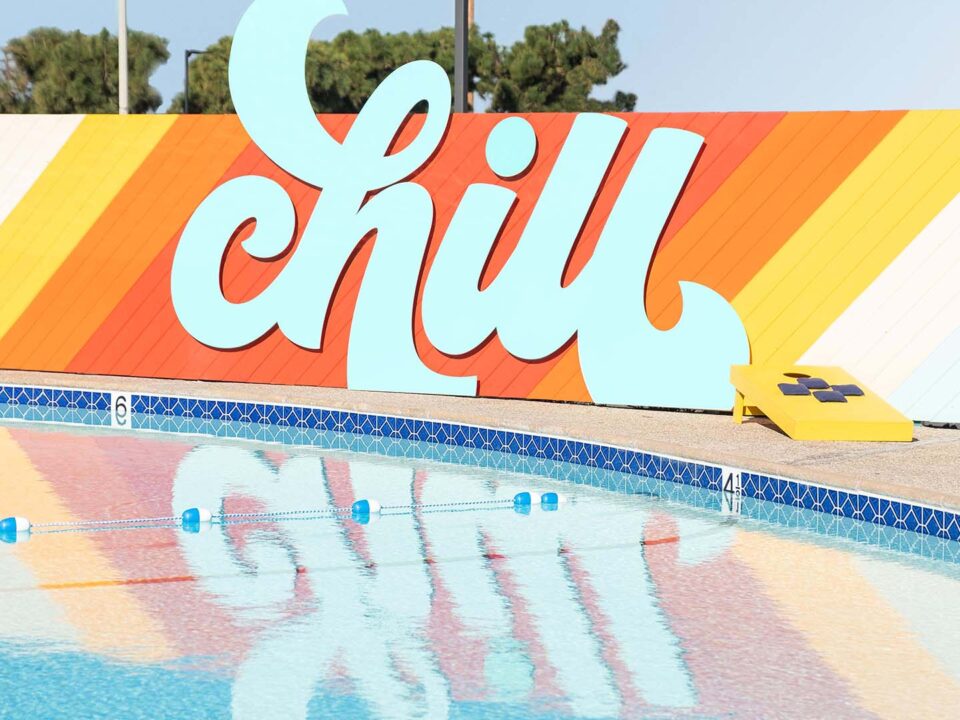Colorful CHILL sign and its reflection on the pool