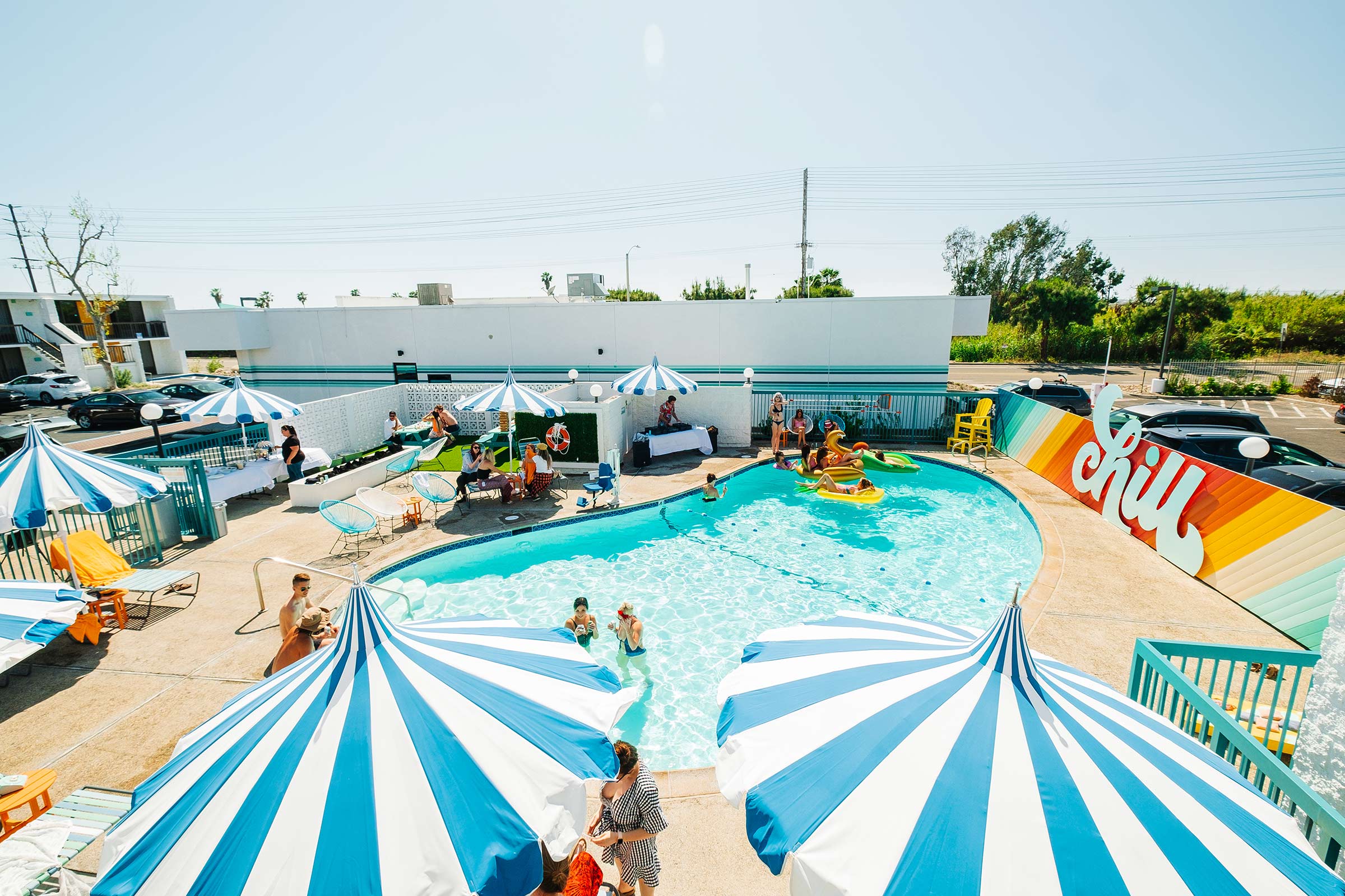 The Rambler Motel pool area with guests floating on rafts and swimming